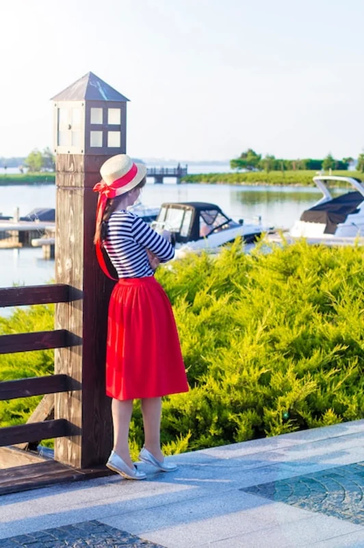 Piękna dziewczyna w słomianym kapeluszu na molu obok jachtów i łodzi